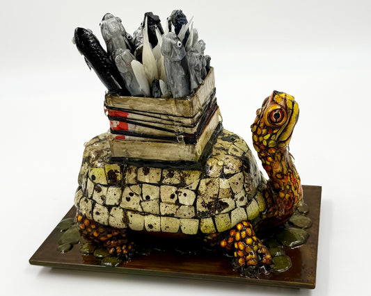 Decorative turtle sculpture with a box full of fish on its back