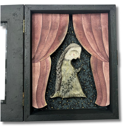 Diorama artwork featuring a women holding a rosary made of ivy