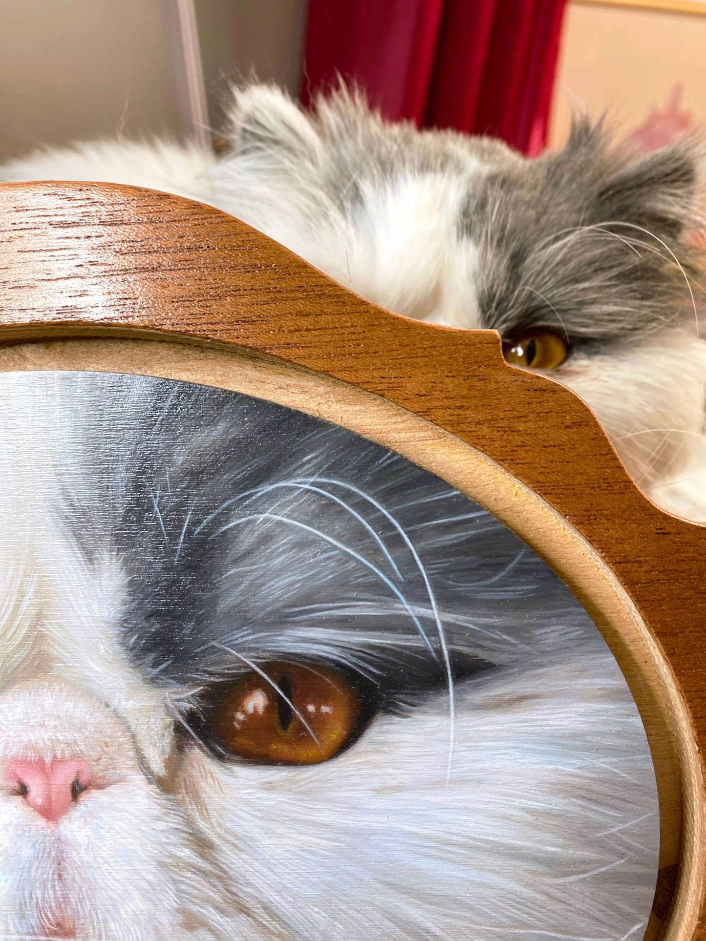 A close-up of Sybiline’s painting Son Altesse with its inspiration peeking over the top.