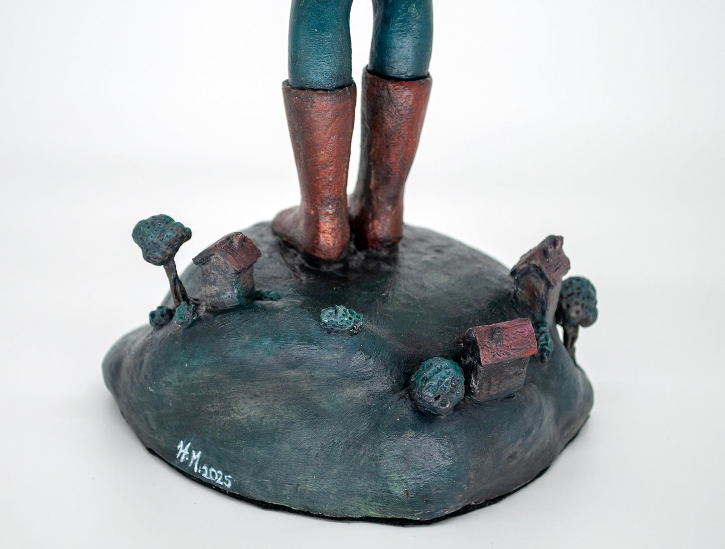 Realistic sculpture of a girl with red hair wearing a yellow raincoat holding a fishbowl above the world