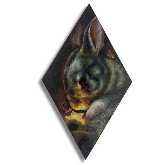 Painting of a rabbit burying a star on a diamond shaped panel