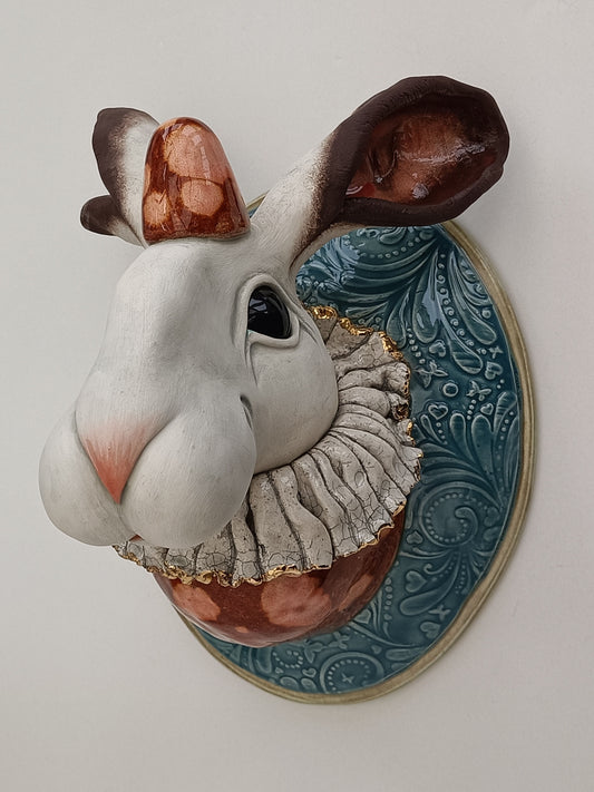 Decorative wall piece of a stylised hare head, wearing a clown outfit.