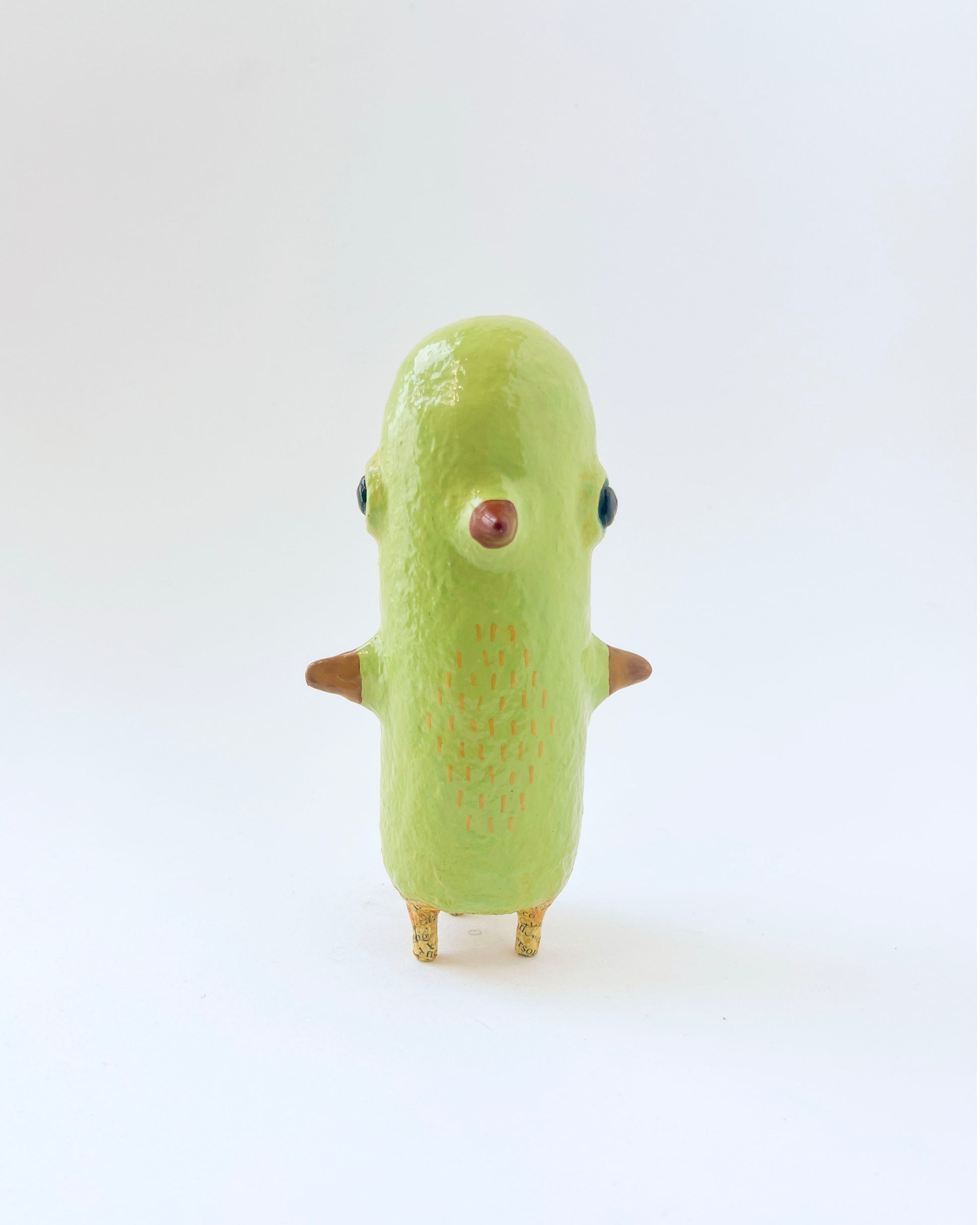Greenish-yellow paper mache bird like creature