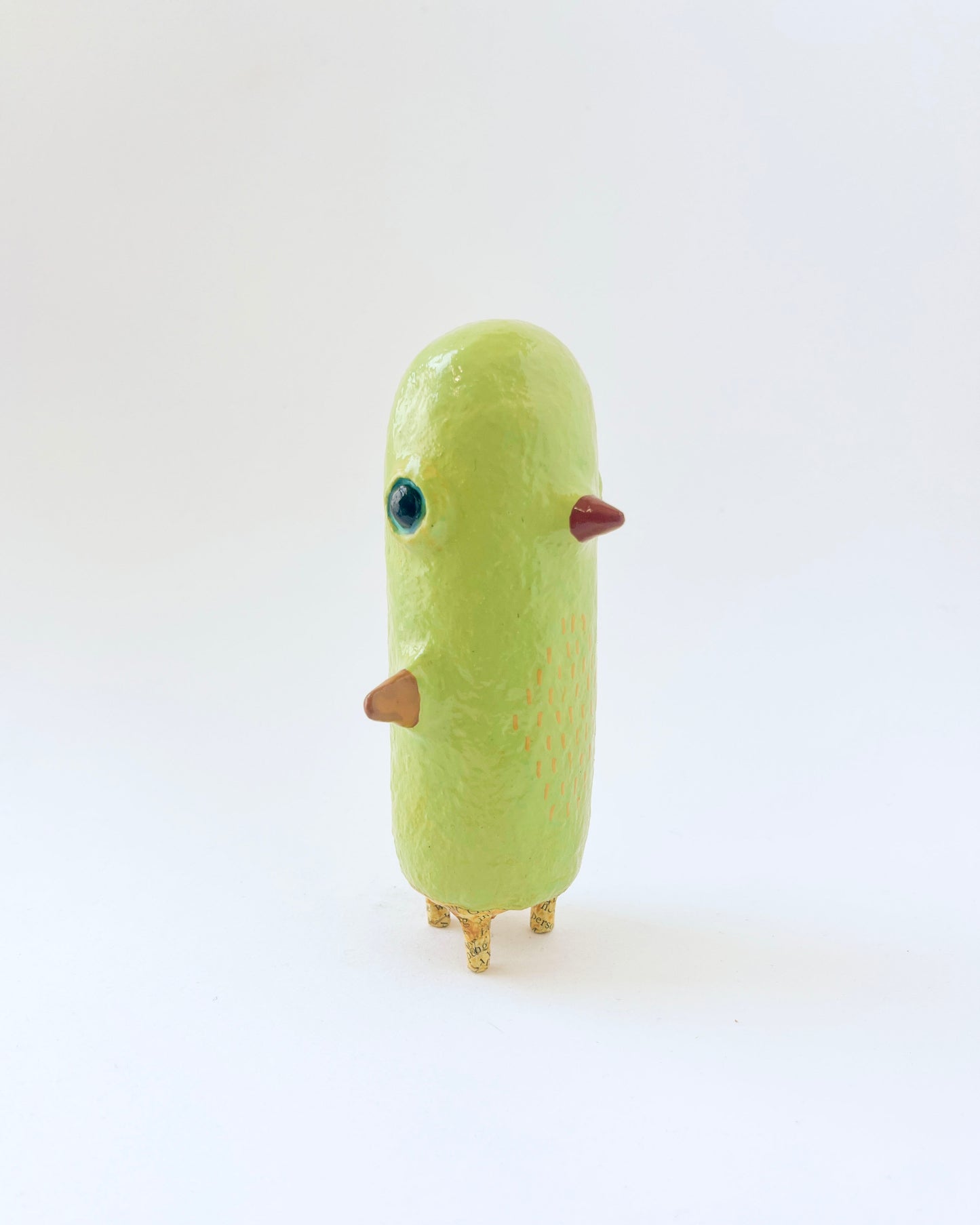 Greenish-yellow paper mache bird like creature
