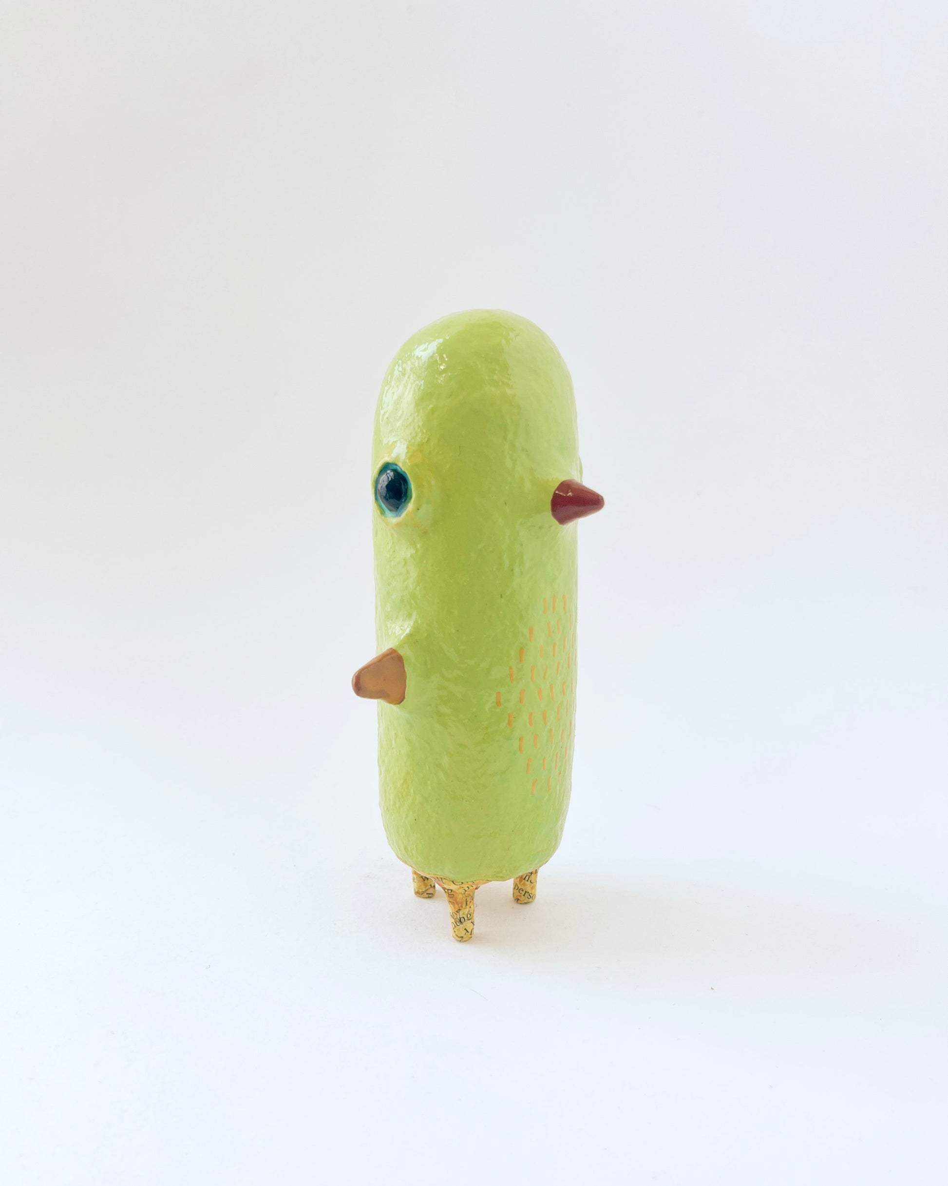 Greenish-yellow paper mache bird like creature