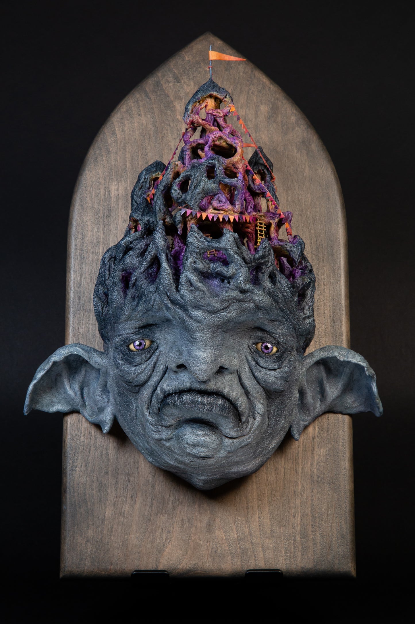 Carefully sculptured wall mounted gargoyle head morphing into a fun house.