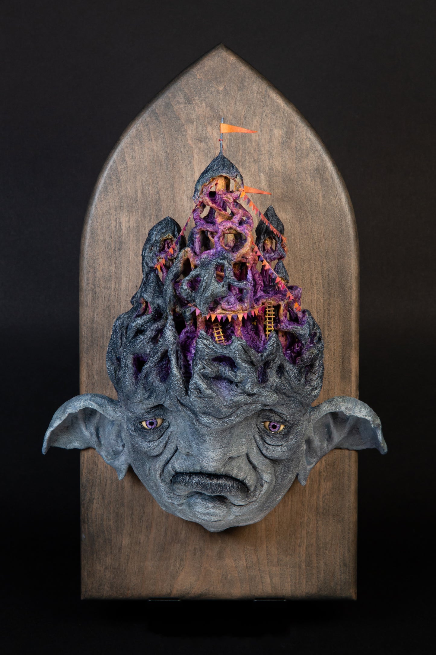 Carefully sculptured wall mounted gargoyle head morphing into a fun house.