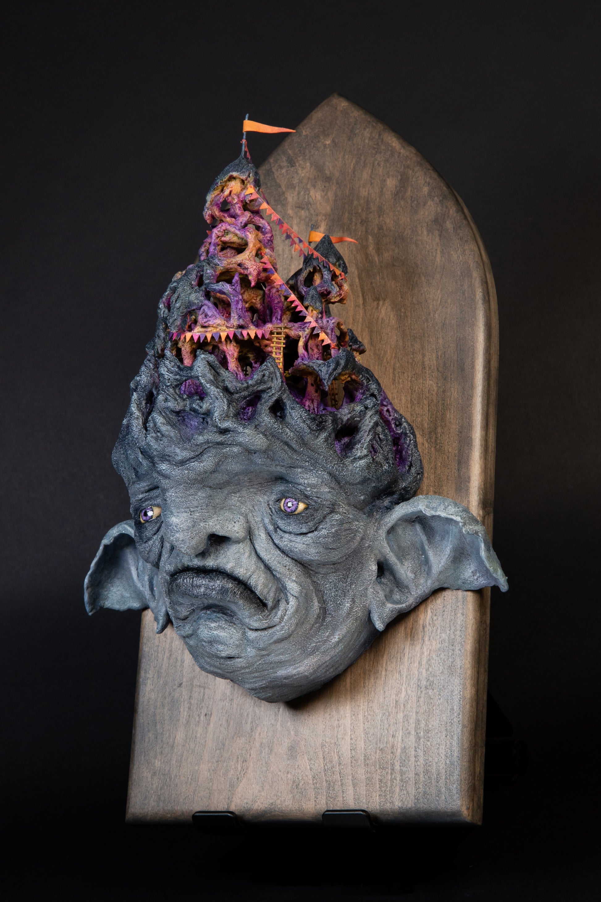 Carefully sculptured wall mounted gargoyle head morphing into a fun house.