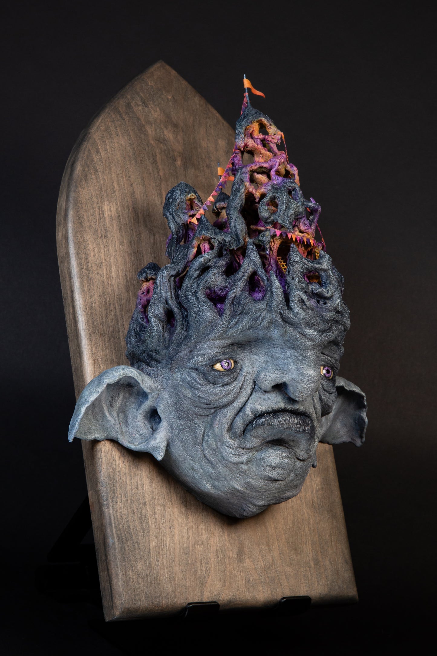 Carefully sculptured wall mounted gargoyle head morphing into a fun house.