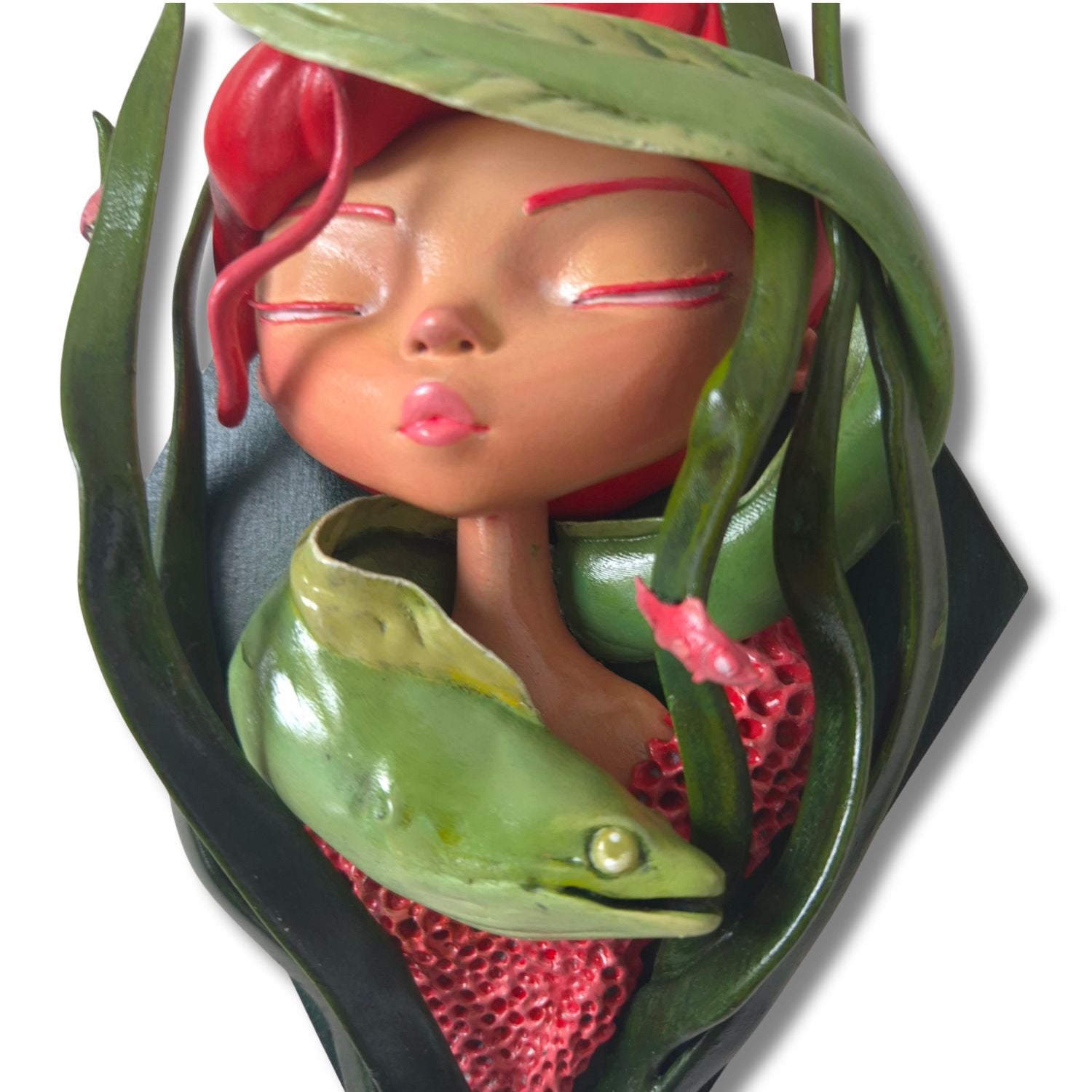 Decorative wall piece with a stylized face surrounded kelp and a sea eel