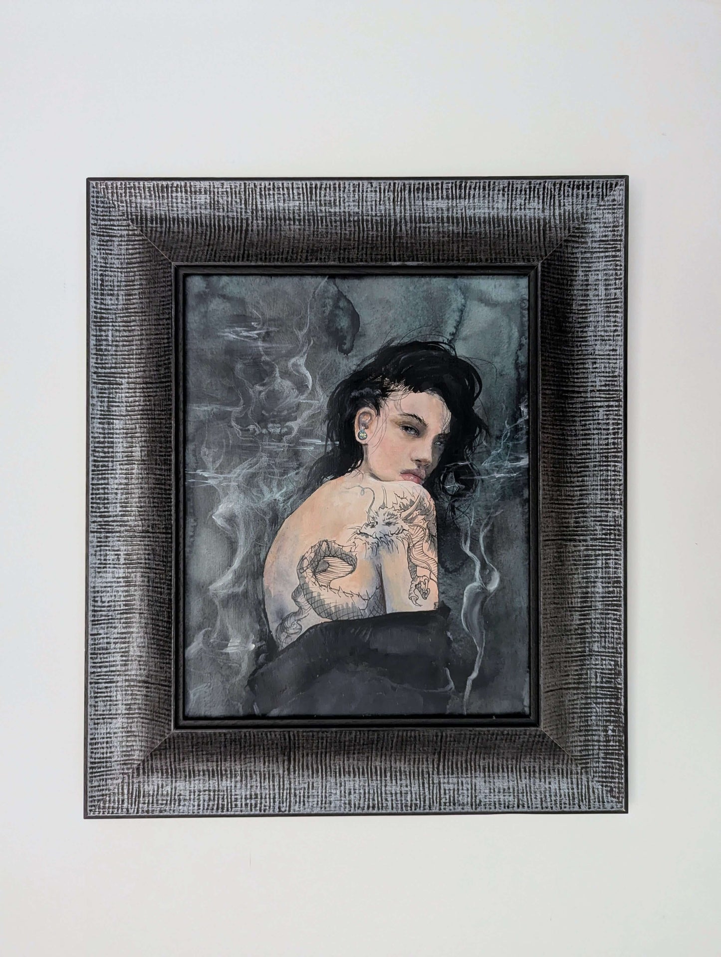 Framed artwork of a woman with tattoos on a gray background