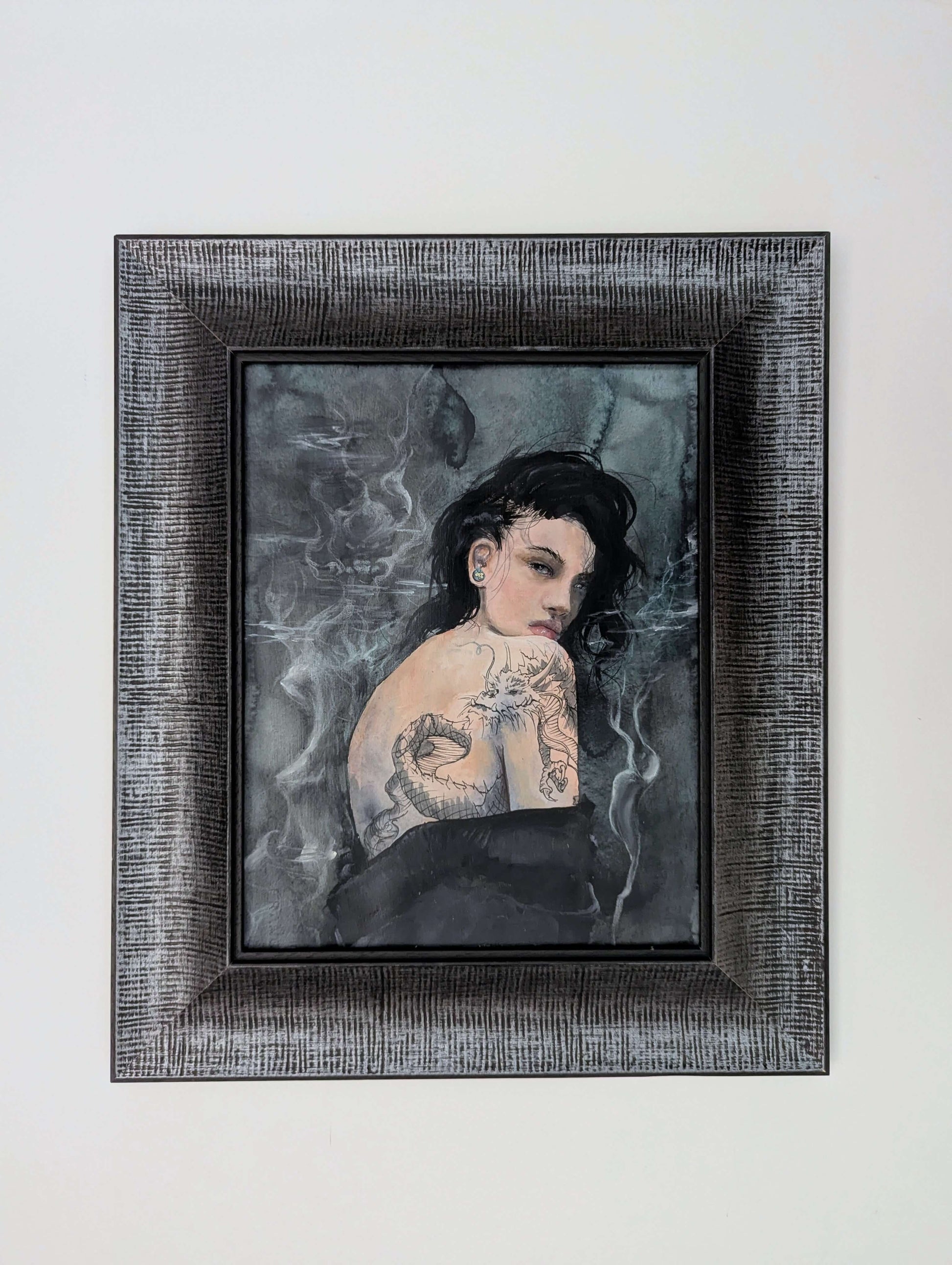 Framed artwork of a woman with tattoos on a gray background