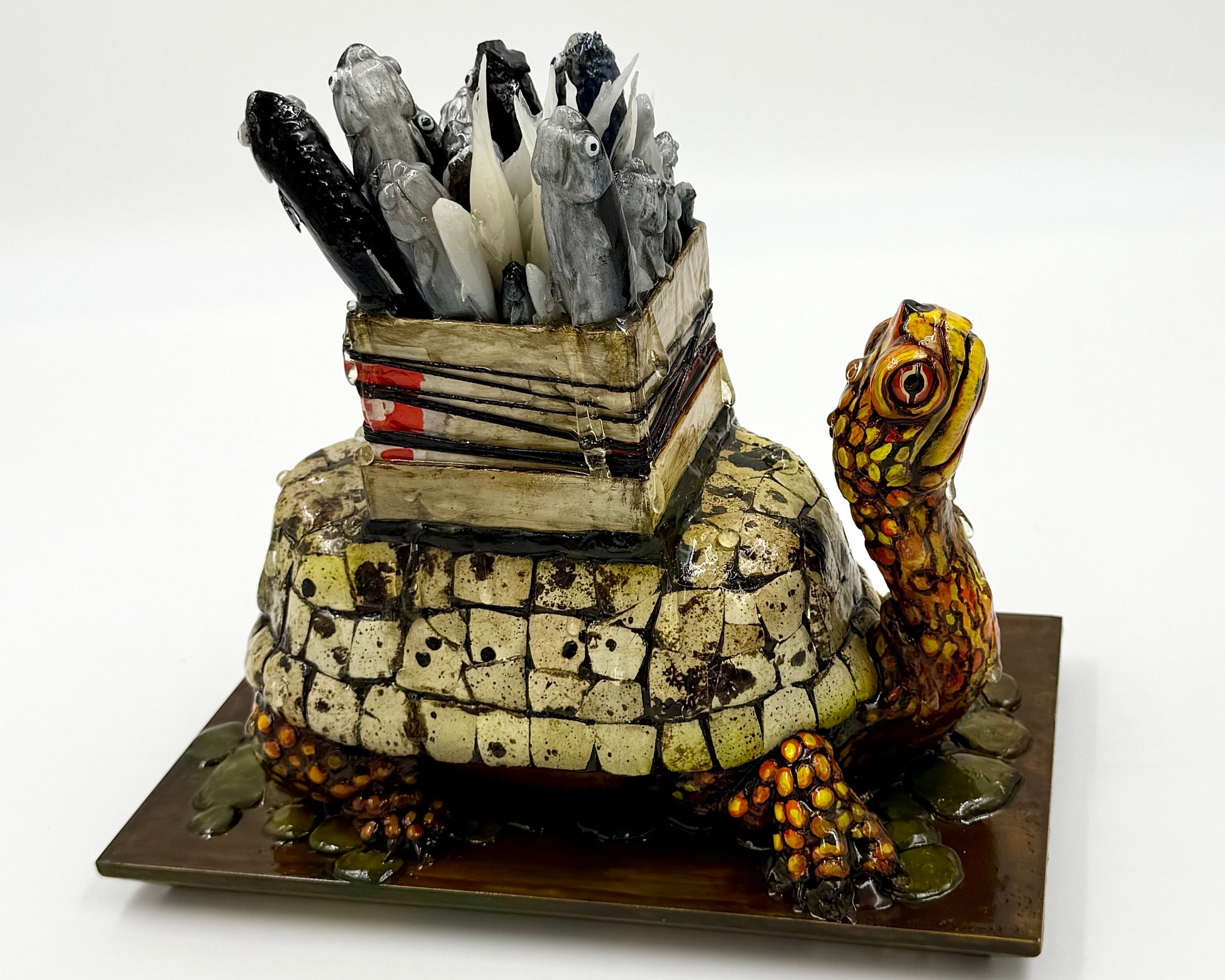 Decorative turtle sculpture with a box full of fish on its back