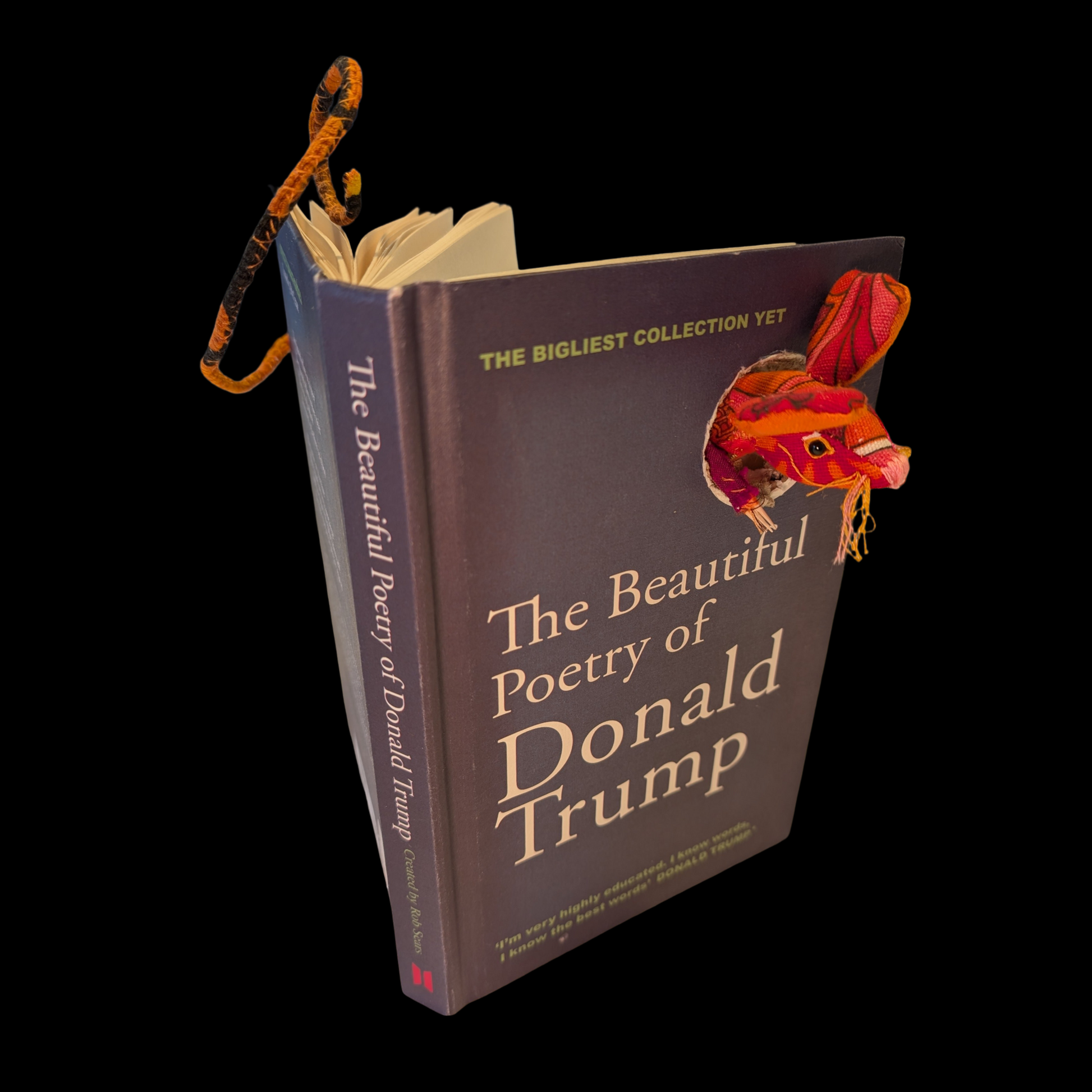 Textile taxidermy rodent destroying a satirical book of poetry by Donald Trump