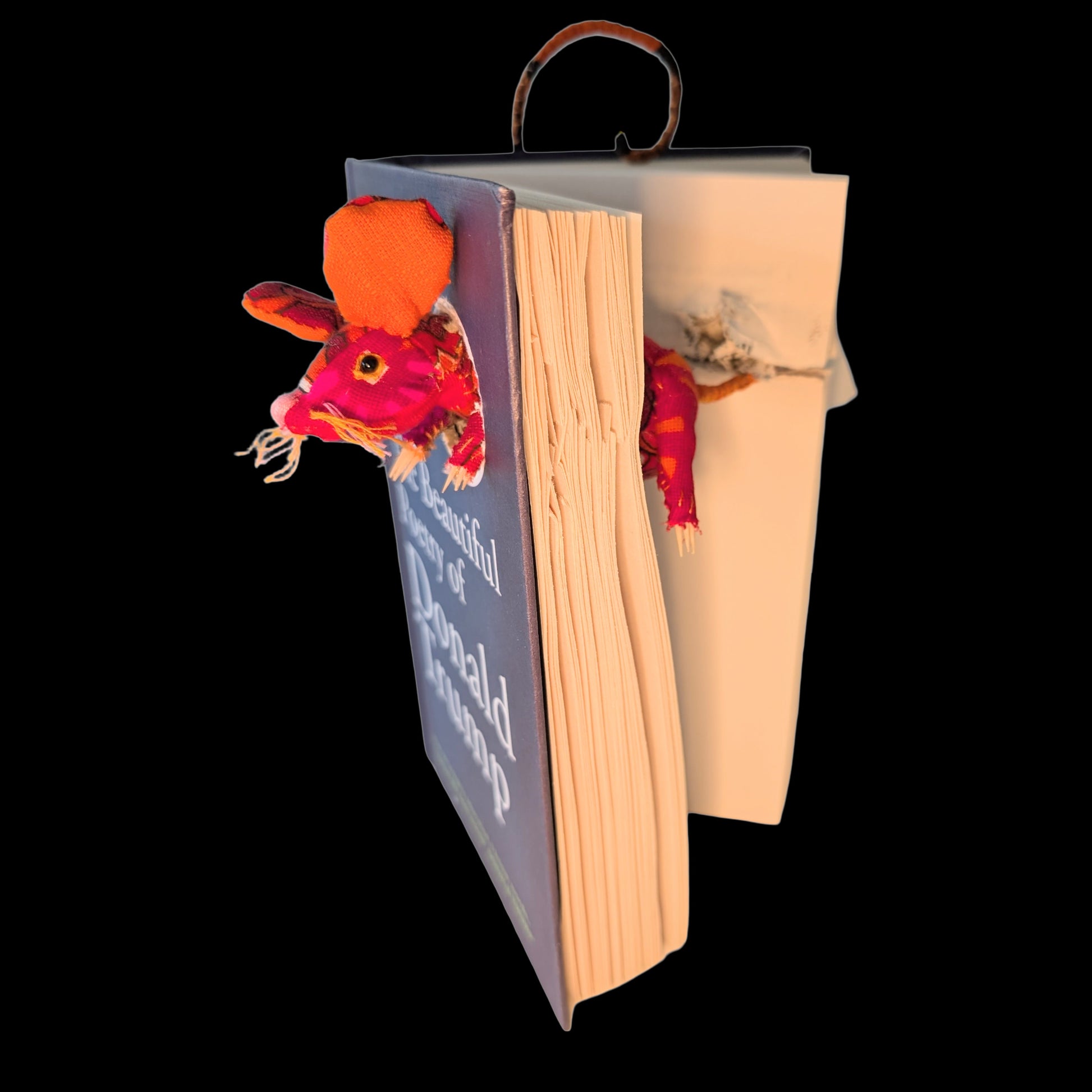 Textile taxidermy rodent destroying a satirical book of poetry by Donald Trump