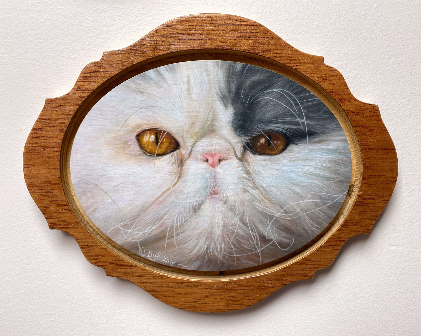 Laser cut framed painting of a fluffy cat with white and black fur and amber eyes.