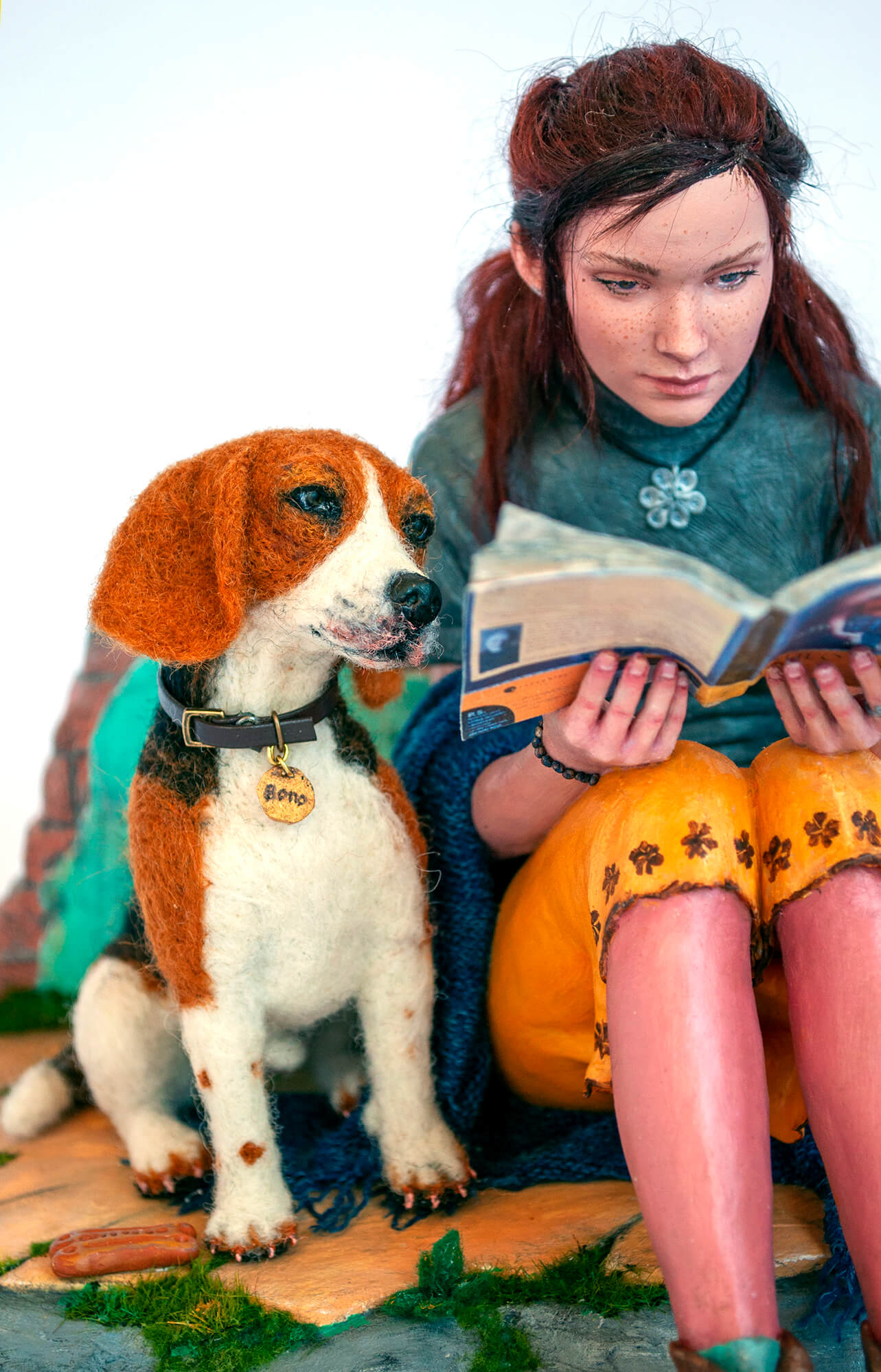 Sculpture of a young woman reading a book to a dog