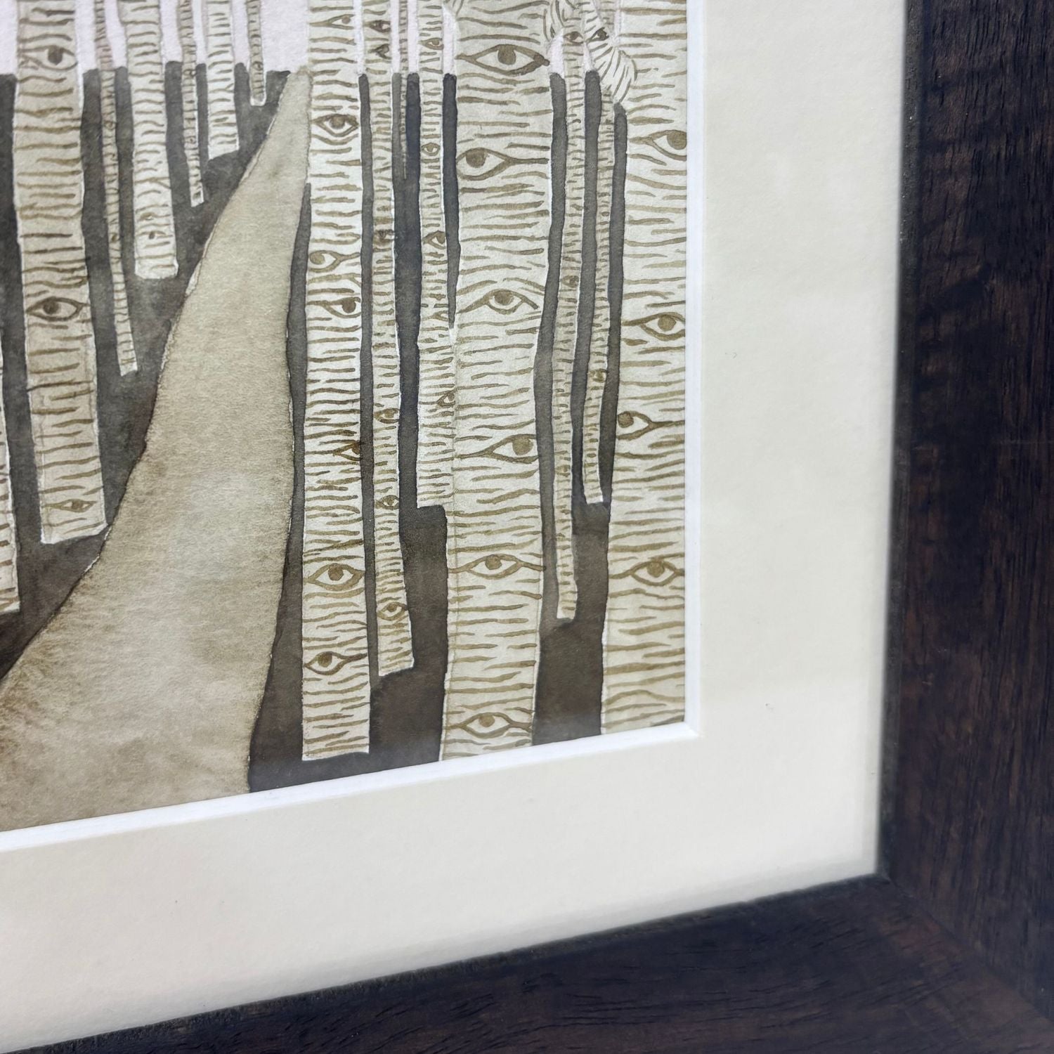 Framed artwork of a forest fill of trees watching the viewer