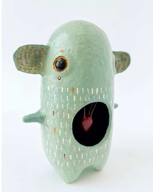 Green paper mache creature with exposed heart