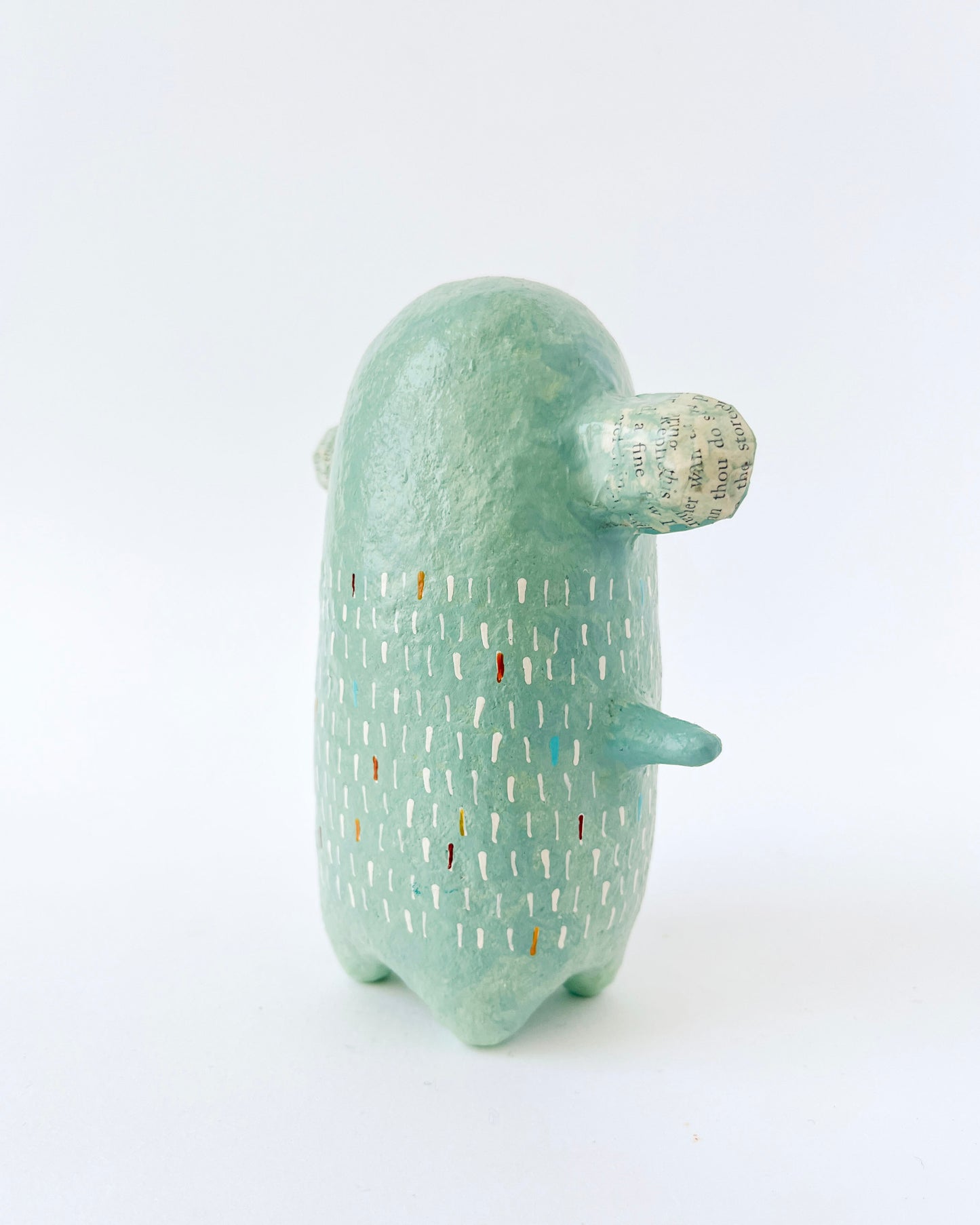 Green paper mache creature with exposed heart