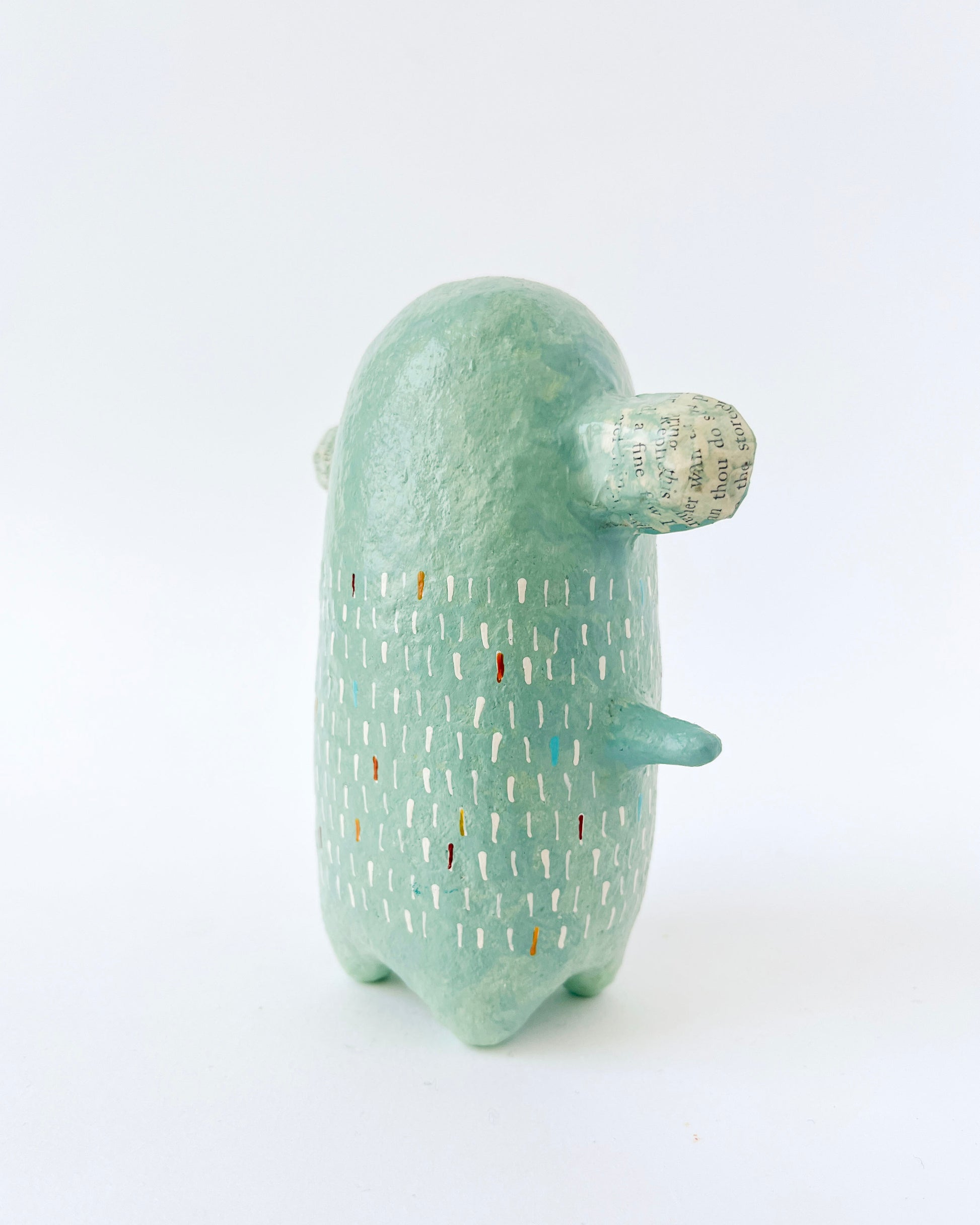 Green paper mache creature with exposed heart