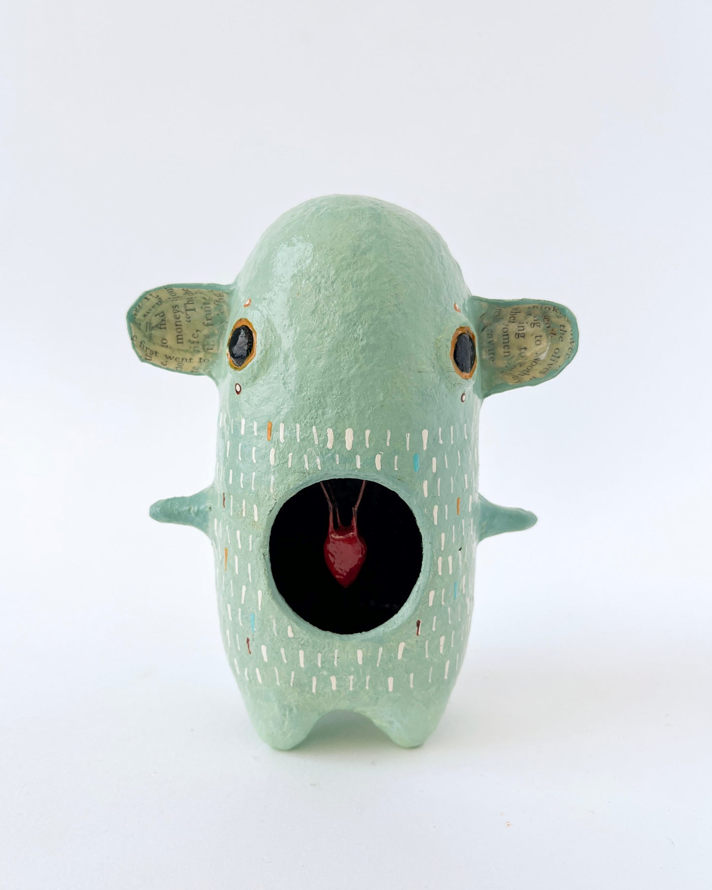Green paper mache creature with exposed heart
